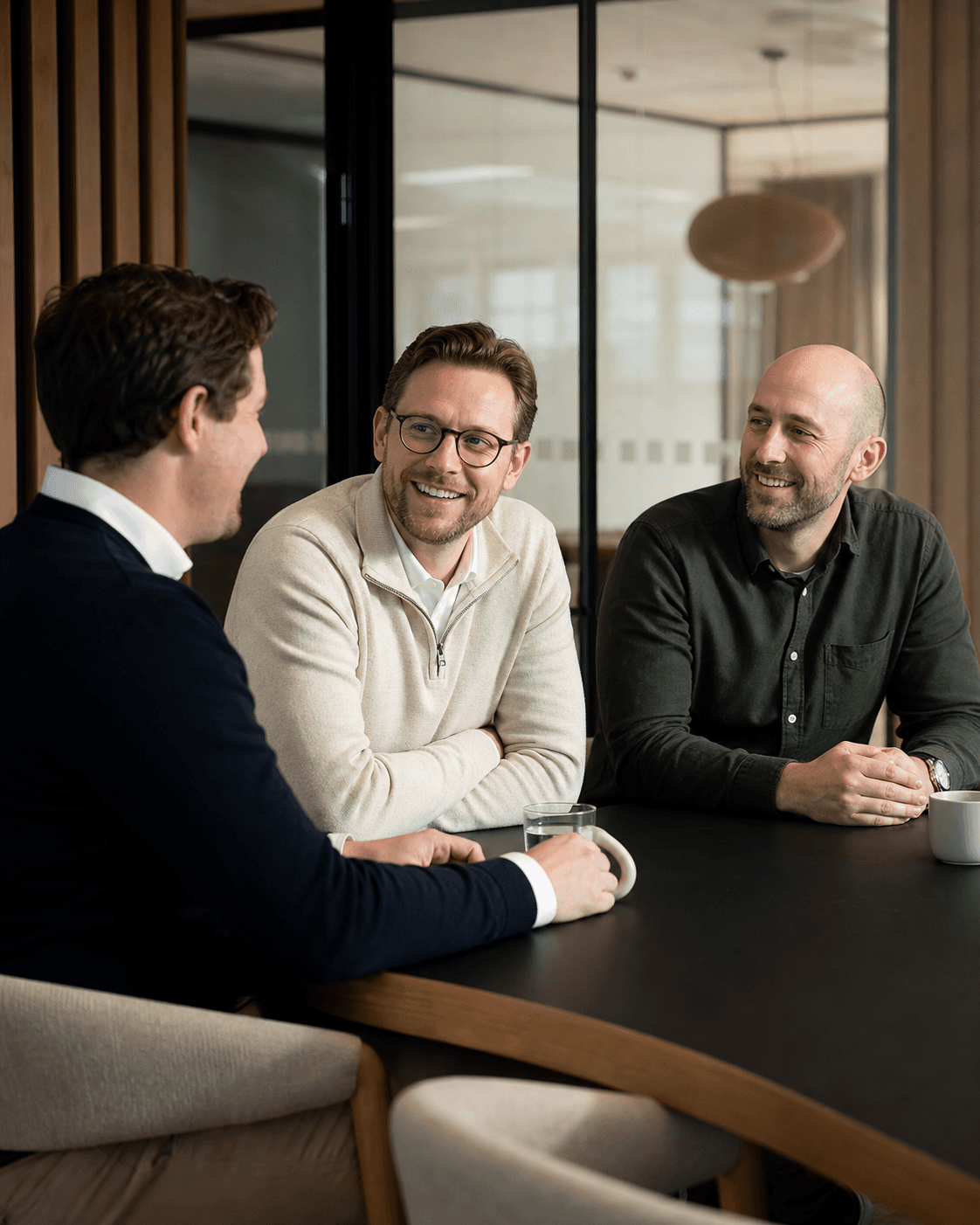 Tre kolleger i samtale i et moderne møterom
